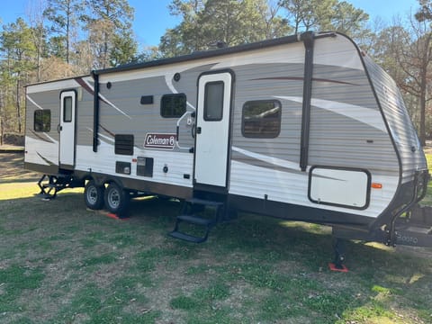 Yard side of the RV.  Two entry doors, canopy, dimmable LED exterior light, propane quick connect, 2x 15' cable lock (to secure items).