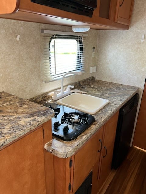 Make delicious meals in this fully equipped kitchen that has a two burner stove, fridge, and sink. Ample food and utensil storage. 