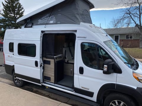 This side view shows the sliding door to enter the back of the van and the pop top opened up for extra sleeping. 