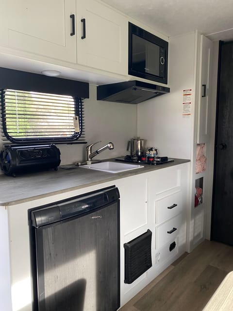 Kitchen area, mini fridge, sink, stove, microwave and cabinets