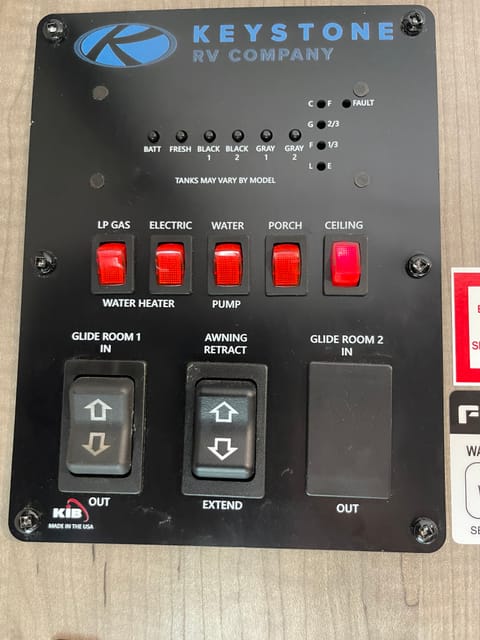 Controls for hot water, awning, slide out, and lights. Meters to check tank levels.