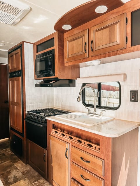 The kitchen has great storage & space, with a double sink & the ability for counter space, & the fridge & freezer to the left.