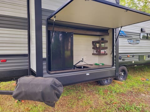 Outdoor Kitchen With Mini Fridge, Sink, Counter Space. Mini Waffle Iron, Gas Grill Attached To Bumper With Swingout Arm. Griddle Grate Attachment. Icee Maker