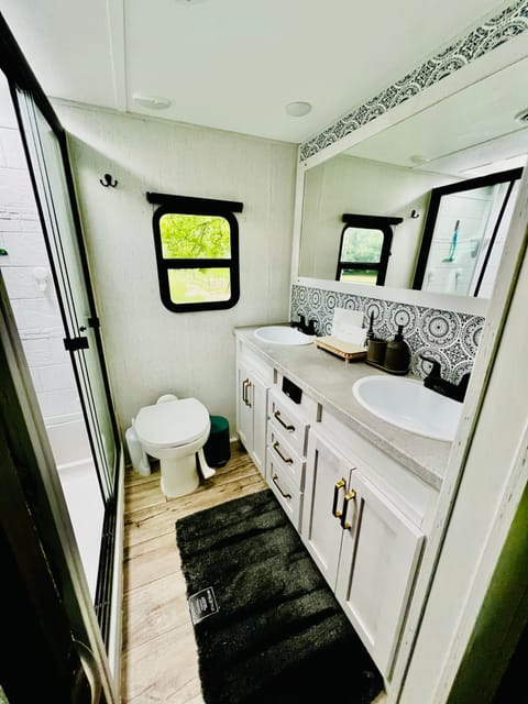 Master/main bathroom with shower, toilet, extended vanity with two sinks, large mirror, plenty of cabinet & drawer space & open shelving