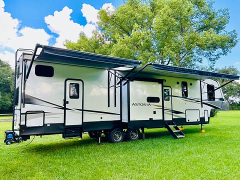 Two entry/exit doors w/ screens on each door, 2 awnings, 3 slides (2 on opposite side); small compartment holds outside beverage fridge and metal rails are for attaching the outdoor griddle