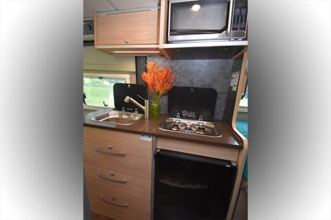 The feature packed kitchen includes a sink, gas cooktop, microwave and fridge and plenty of storage.