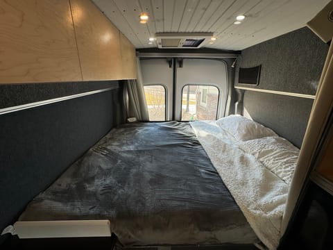 Bedding features short queen mattress. Plenty of charging options and also reading lights/storage nets for convenience. Skylight above the bed can be opened if needed.