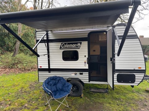 It's exterior features a sleek design accented by LED lights under the awning, creating a warm and inviting ambiance for evening gatherings. Enjoy the comfortable outdoor space with friends and family. 