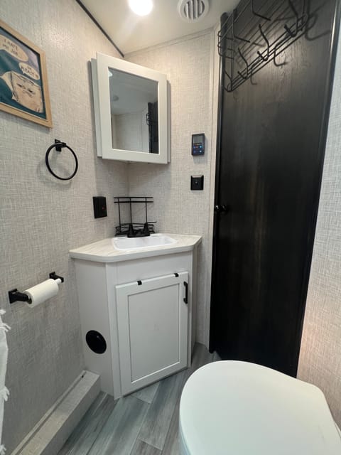 Bathroom sink w/vanity, door, outlets, water temp controller.