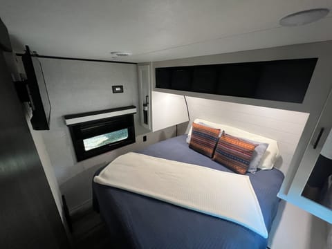 Main bedroom, up front.  Queen size bed, TV, two windows, power outlets, storage spots.