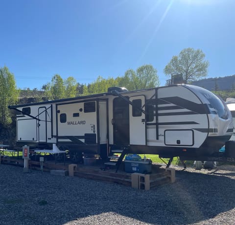 Its sleek, aerodynamic design makes towing smooth and efficient, while the durable fiberglass exterior and power tongue jack make setup a breeze. A large electric awning with LED lighting creates the perfect outdoor living space for relaxing or dining under the stars. The outdoor kitchen complete with a mini fridge, and cooktop. Ample pass-through storage lets you easily pack all your camping, fishing, or hunting gear. With outdoor speakers, stabilizer jacks, and Separate entrance for bathroom.