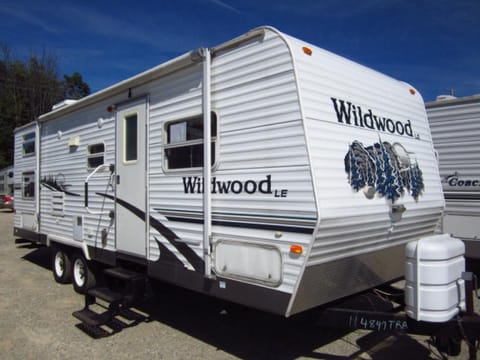 This Wildwood trailer looks fresh and nice with bright and appealing colours of white with blue. There are lots of windows and a patio blind for either sunny or drizzly days. It looks nice in any campground. Almost looks like it was just driven off the dealership lot!
