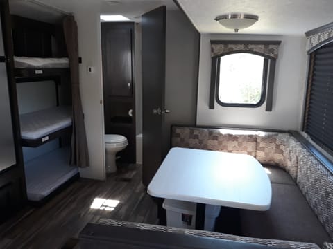 2019 view of dinette and triple bunk.  Newer trailers go to customers who book first.  
