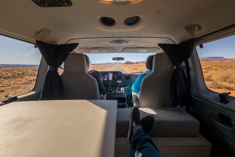 The interior view of the van when sitting. There are privacy curtains that wrap all the way around the van that can be shut when needed. 