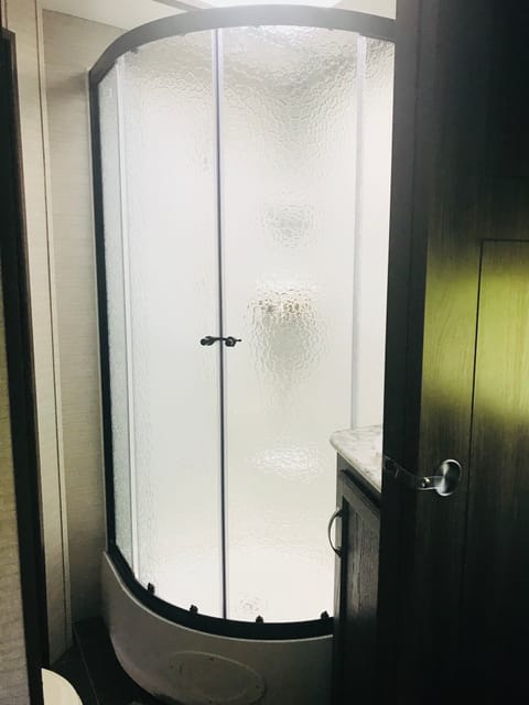 Corner enclosed stand up shower connects to master and living area. 