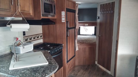View of the kitchen and the bunk beds.  The door on the right is to the bathroom.