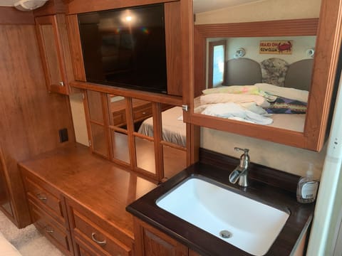 Bathroom sink and dresser in master bedroom and flat screen