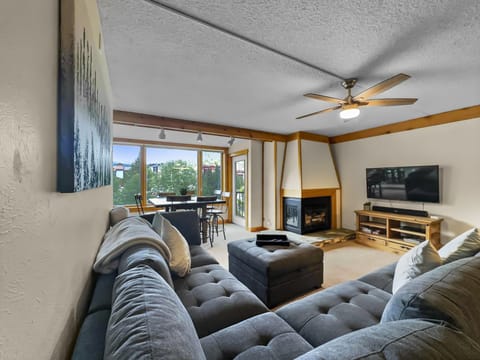 Large sectional sofa looking towards patio access, fireplace, and TV