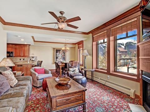 A vibrant living room featuring ample seating, large windows allowing natural light in.