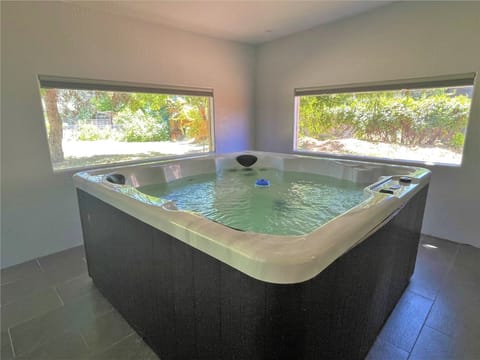 There is a large indoor hot tub with serene views of the gigantic private back yard.