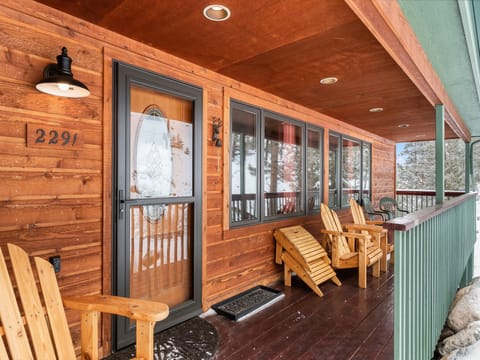 Estes Escape - Porch with front door and four Adirondack chairs