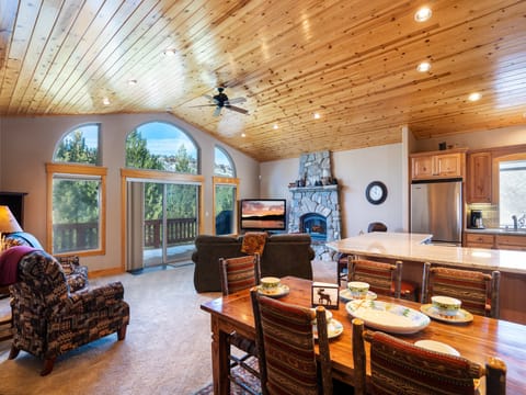 Discover tranquil living in this bright great room, featuring stunning pine ceilings, a cozy natural stone fireplace, and a 60" smart TV—all while overlooking the beautiful Tahoe pine trees.