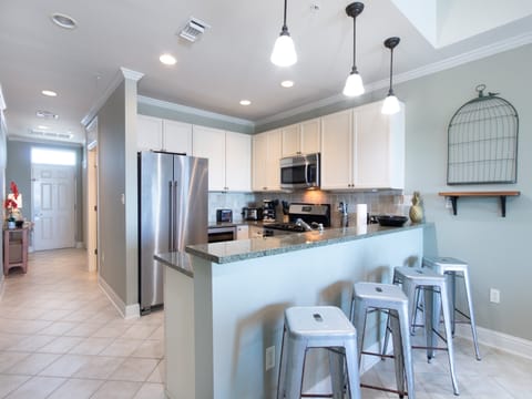 The spacious kitchen offers an eat-in style bar with seating for 4. Stainless appliances are featured in this open space and include a side by side refrigerator, gas stove, built in microwave, ice maker, wine cooler and dishwasher