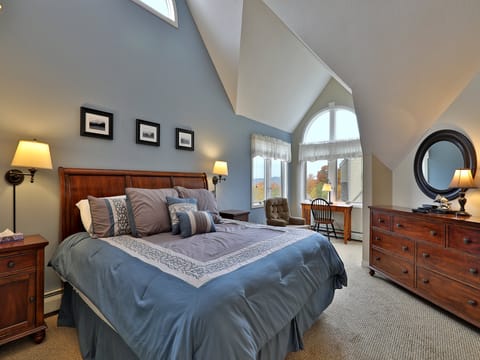 Master bedroom with vaulted ceilings and a King size bed.