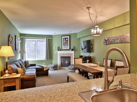 Open kitchen with comfy living room and gas fireplace.