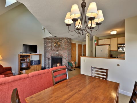 View from the dining area into the living room with wood burning fire place