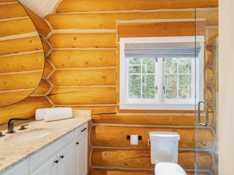 Guest Room 2 features a cozy ensuite restroom with plenty of vanity space for guests.