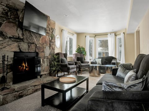 Living room perfect for gathering with flagstone firestone hearth, flat screen TV and plenty of seating