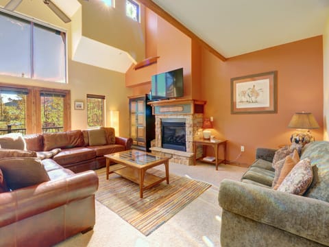 Cozy living room features a lot of natural light, a fireplace, and large TV