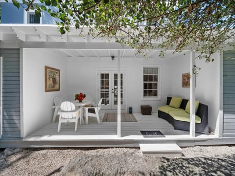 Outdoor patio with seating and dining looking into lush gardens.