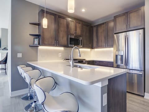 Modern condo features an updated kitchen with bar stool seating area.