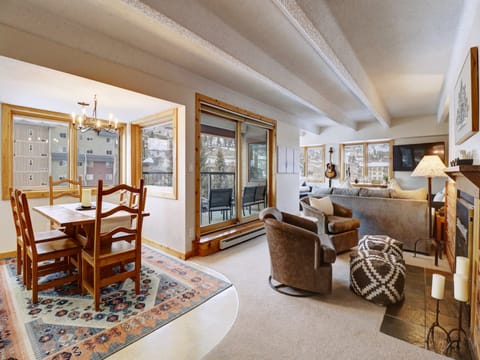 Cozy. open concept living space featuring ample seating, a nice dining room table, fireplace, and large TV.