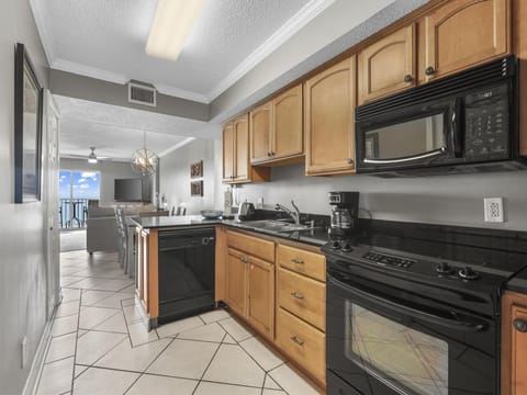 The spacious kitchen features electric appliances, which include a built-in microwave, smooth cooktop range, dishwasher, and refrigerator with ice maker.