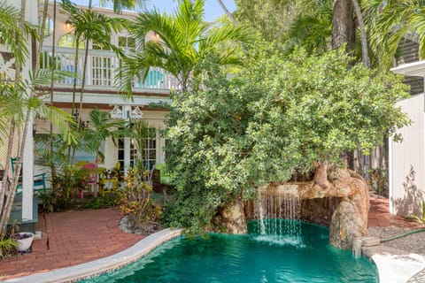 Shared pool area with a waterfall, grotto, and large patio.