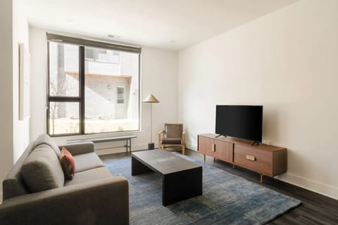 Cozy living room, with TV and a large window.