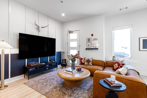 Spacious living room with a large sectional and flatscreen TV.