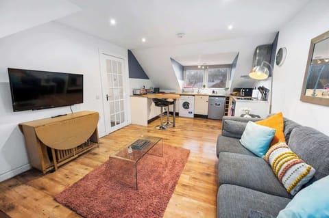 Living area with ample lighting, comfortable seating, and a TV