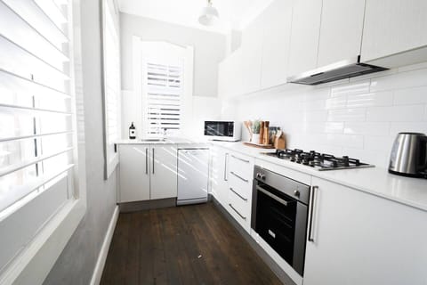 A bright kitchen equipped for all your cooking needs, and fitted with a stove, oven, microwave, and kettle.
