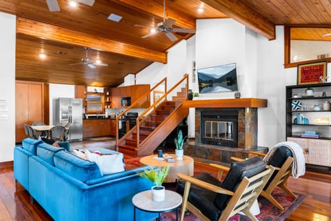 Choose your spot in our open-concept retreat, complete with a well-equipped kitchen, versatile seating, and a charming wooden staircase beckoning to the upper level.