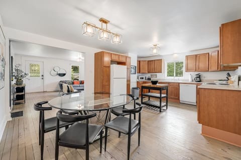 Nicely remodeled kitchen with new white appliances, large 6-person glass dining table, and a fully-stocked kitchen