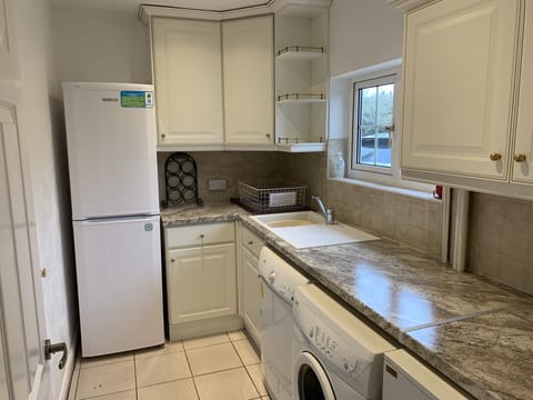 UTILITY ROOM WITH WASHING MACHINE DRYER SINK LARGE FRIDGE FREEZER.