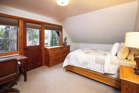 Spacious queen bedroom with desk and private balcony. 