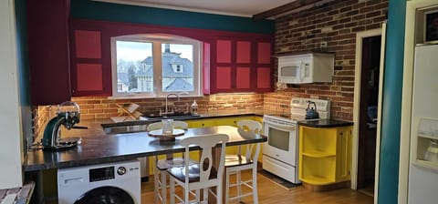 Large colorful kitchen with peninsula seating; includes combination washer/dryer
