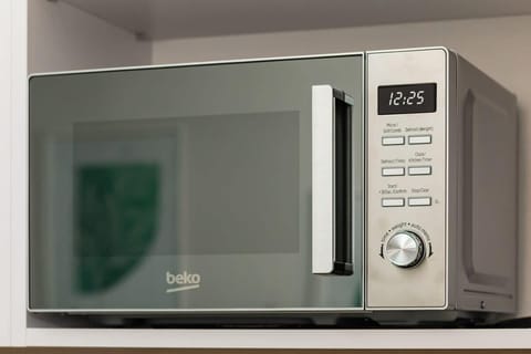 A close-up of a modern microwave with a digital display.

