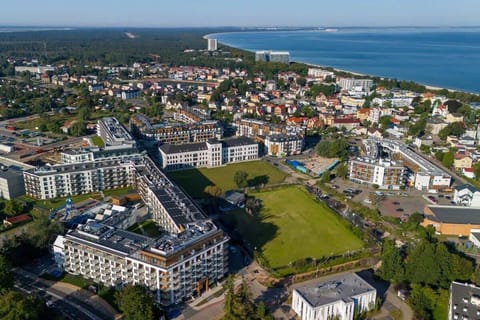 An aerial view of a coastal residential area with modern buildings and a scenic coastline.








