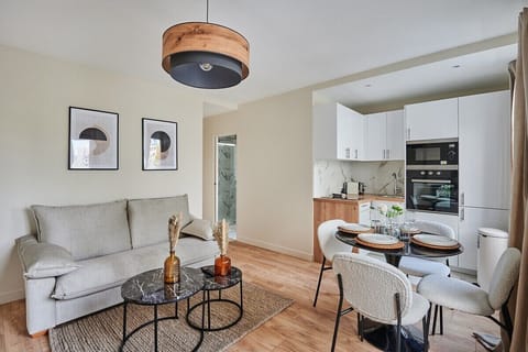 Salon avec canapé lit , cuisine américaine et coin repas